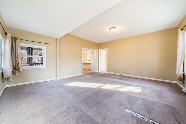 unfurnished bedroom featuring baseboards, carpet floors, and visible vents