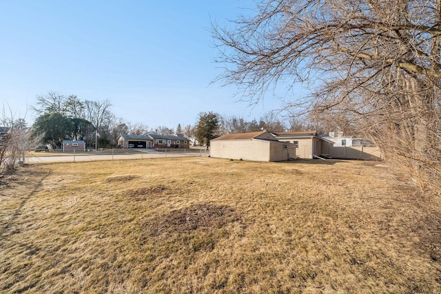 view of yard featuring a carport, driveway, and fence