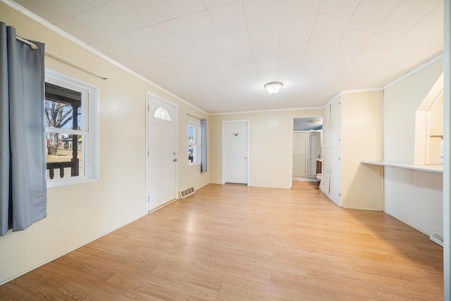 entryway with visible vents, light wood-style flooring, and crown molding