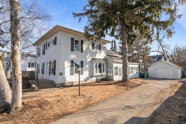 view of front of home with a detached garage, an outdoor structure, and driveway