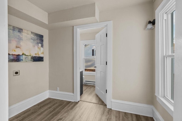 interior space featuring wood finished floors, baseboards, and a baseboard radiator