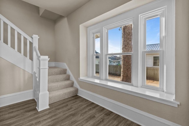 staircase with baseboards and wood finished floors