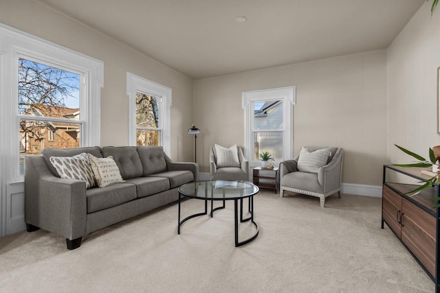 living room with a wealth of natural light, light colored carpet, and baseboards