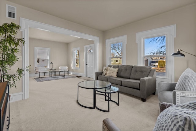 carpeted living room with visible vents and baseboards