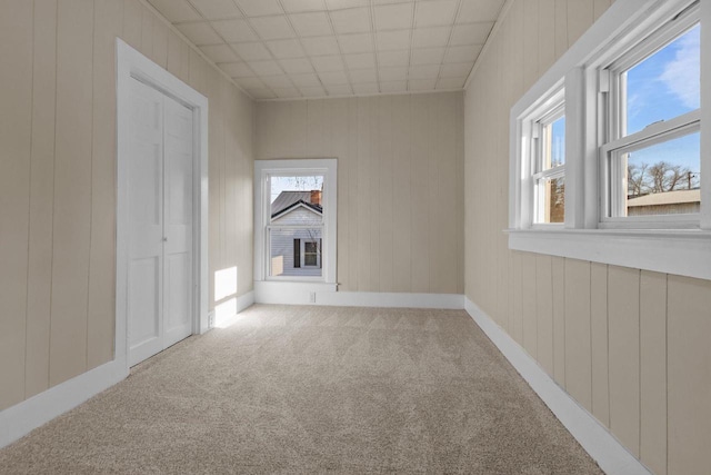 carpeted empty room featuring baseboards