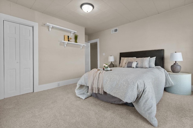 carpeted bedroom featuring visible vents and a closet