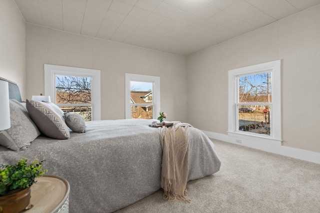 carpeted bedroom with multiple windows and baseboards