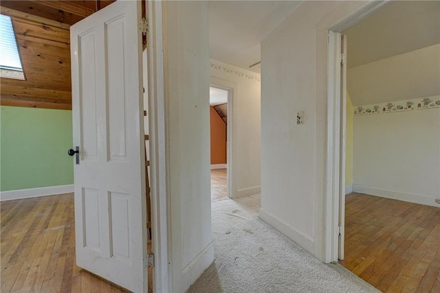 corridor featuring baseboards and hardwood / wood-style flooring