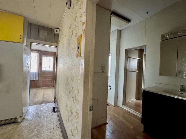 hallway featuring wood finished floors and a sink