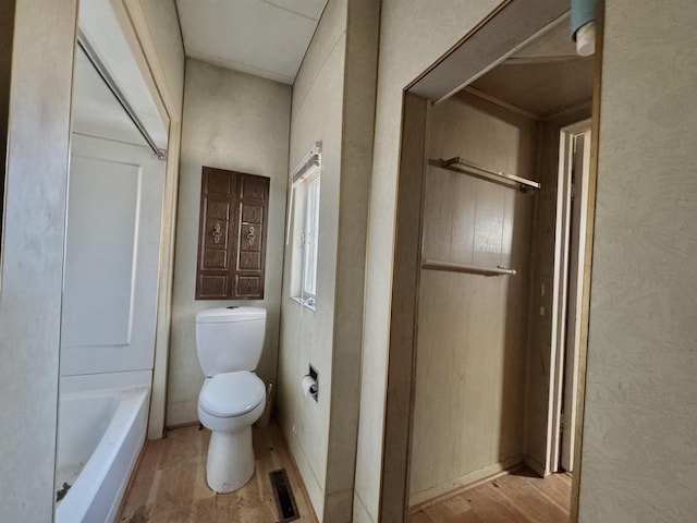 full bath featuring visible vents, toilet, a bathtub, wood finished floors, and a shower