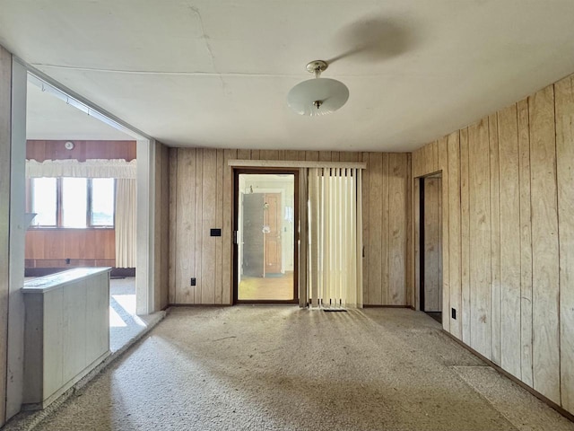 empty room featuring wooden walls and carpet floors