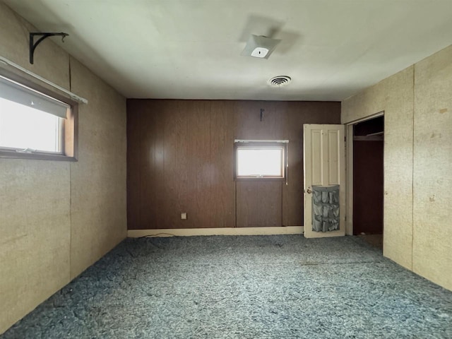 carpeted empty room featuring visible vents