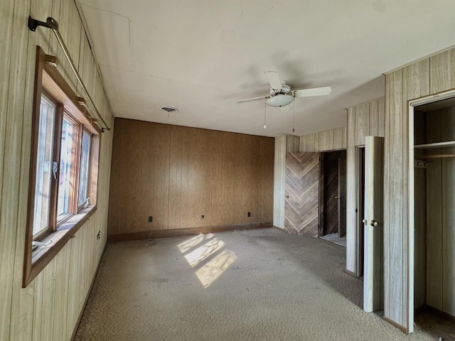 unfurnished bedroom with ceiling fan, light colored carpet, visible vents, and baseboards