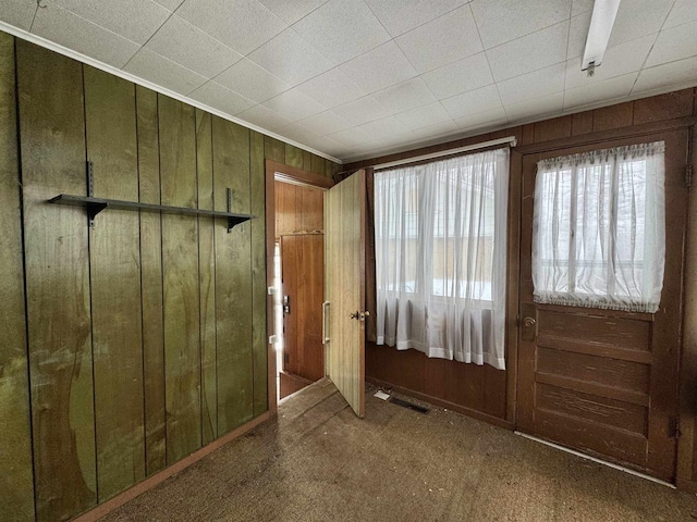 foyer with visible vents and wood walls