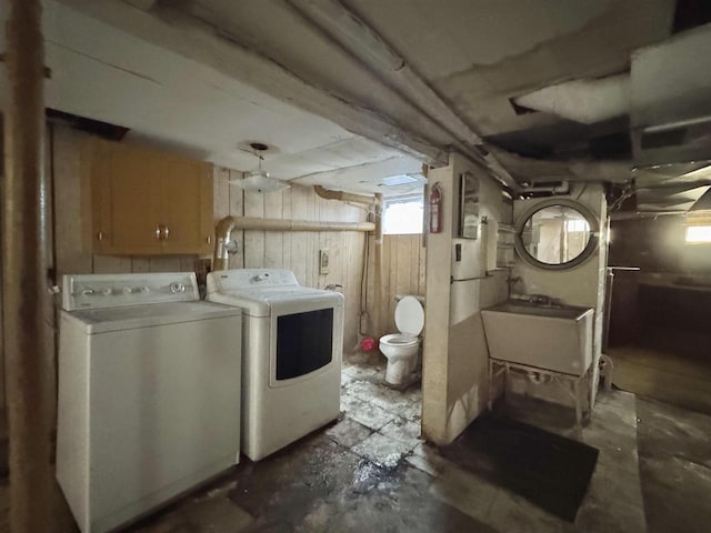 clothes washing area featuring independent washer and dryer and a sink