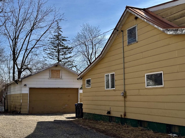 view of property exterior featuring a detached garage and an outbuilding