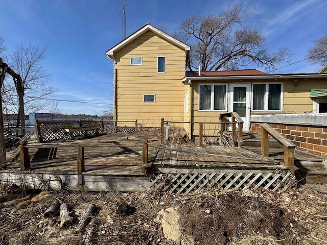 rear view of property with metal roof and a wooden deck