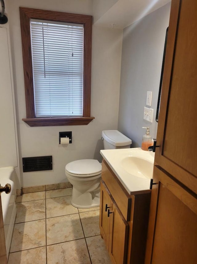 bathroom featuring visible vents, toilet, a washtub, tile patterned flooring, and vanity