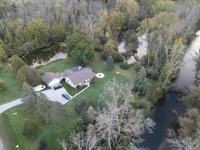 drone / aerial view featuring a forest view and a water view