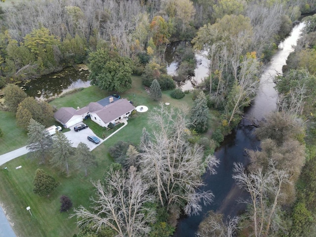 birds eye view of property with a forest view and a water view