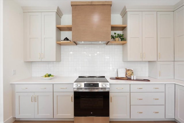 kitchen featuring open shelves, electric stove, light countertops, and range hood