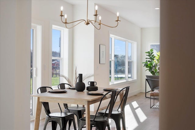 dining space featuring a notable chandelier and baseboards