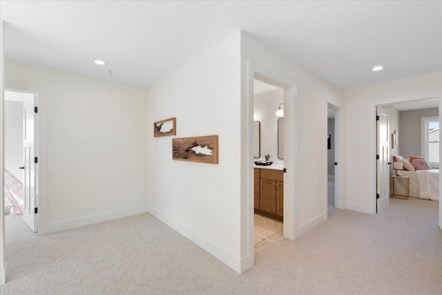 corridor with recessed lighting, baseboards, and light carpet