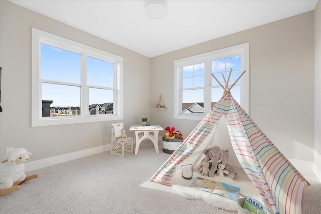 rec room featuring carpet flooring, a healthy amount of sunlight, and baseboards