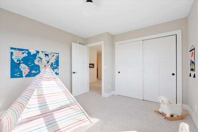 bedroom featuring light colored carpet, visible vents, a closet, and baseboards