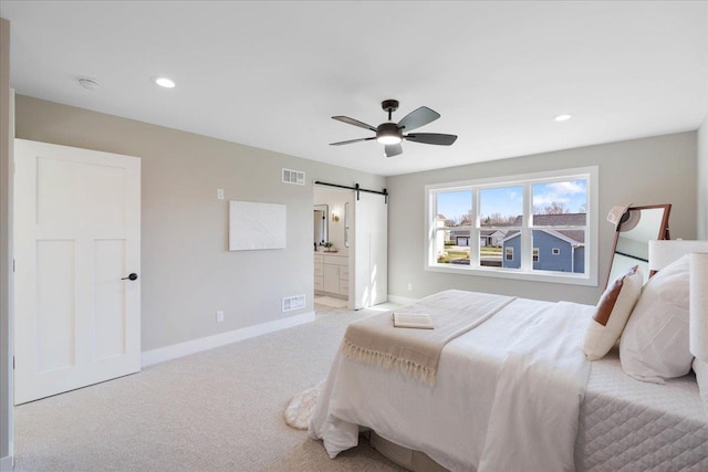 bedroom with visible vents, carpet flooring, baseboards, and a barn door