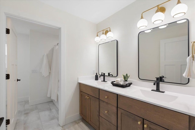 full bath featuring a sink, baseboards, and double vanity