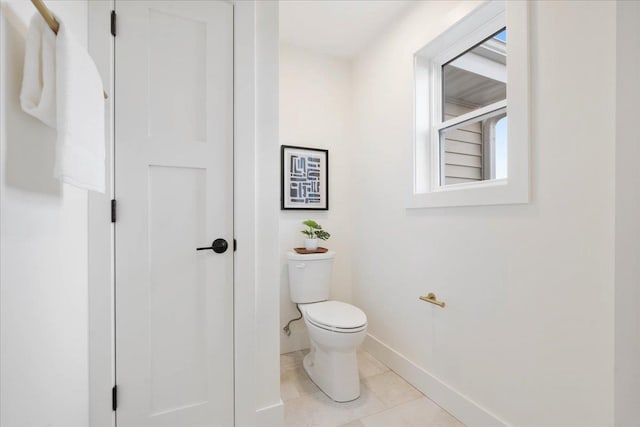 bathroom with tile patterned floors, toilet, and baseboards