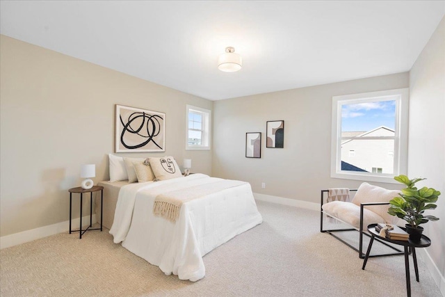 bedroom with baseboards and light carpet