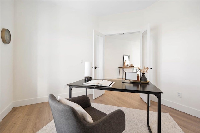 office with light wood-style flooring and baseboards