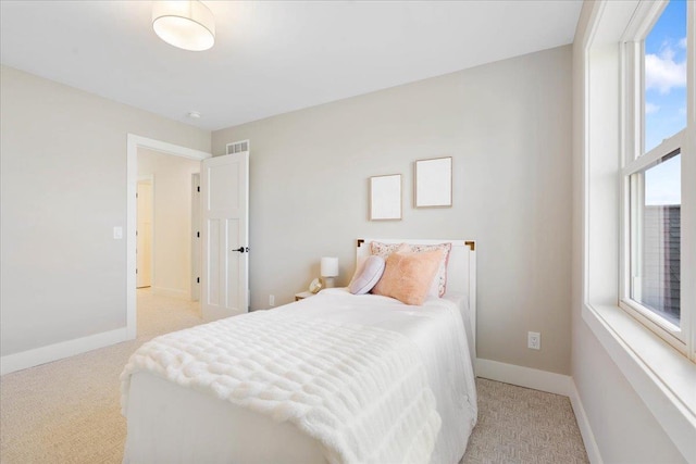 bedroom with baseboards and light carpet