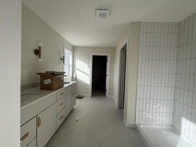 full bath featuring a sink, baseboards, and double vanity