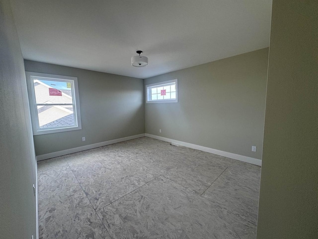 unfurnished room with baseboards