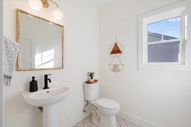 bathroom with a sink, baseboards, and toilet