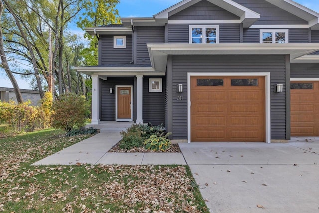 multi unit property featuring a garage and concrete driveway