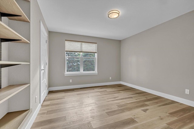 empty room with baseboards and light wood-style floors