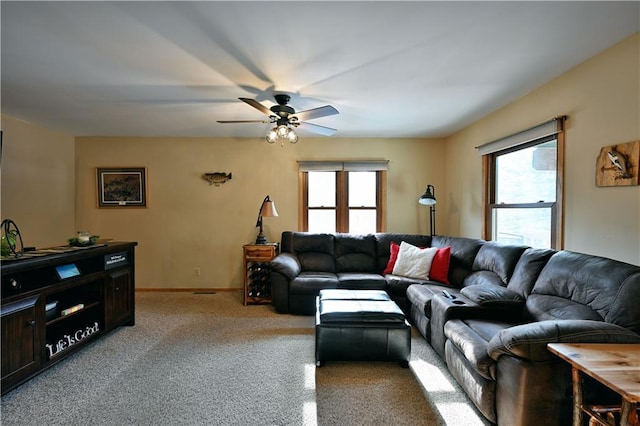 carpeted living area featuring baseboards, a healthy amount of sunlight, and a ceiling fan