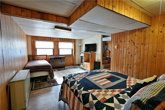 bedroom featuring wooden walls and wood finished floors