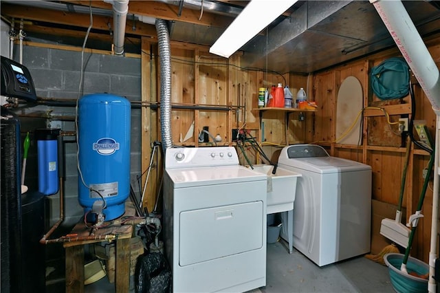 laundry room with laundry area, washing machine and dryer, and concrete block wall