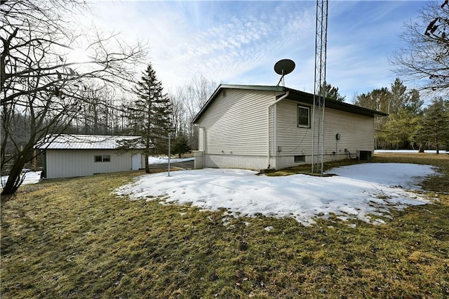 snow covered property with an outbuilding and central AC unit