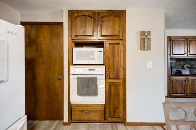 kitchen featuring white appliances and light wood-type flooring