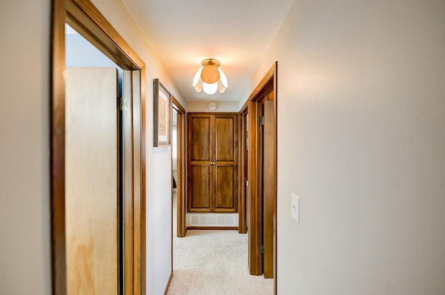 hall featuring visible vents and light carpet