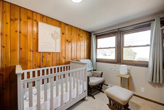 bedroom with baseboards, carpet, wood walls, and a textured ceiling