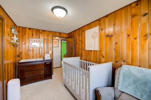 bedroom featuring light colored carpet and wood walls