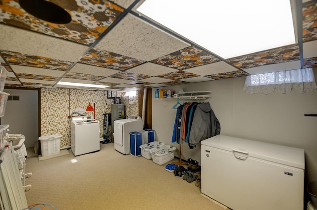 below grade area with white refrigerator, a drop ceiling, and separate washer and dryer