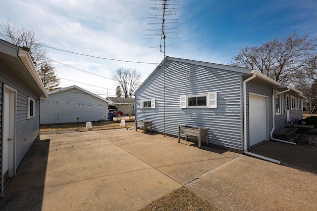 view of side of home featuring concrete driveway